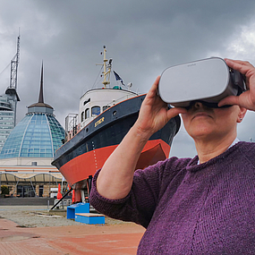 Frau mit VR-Brille vor dem Schiff Stier.