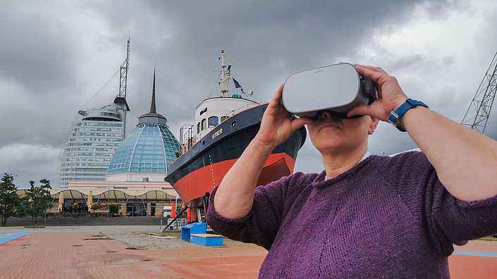 Frau mit VR-Brille vor dem Schiff Stier.