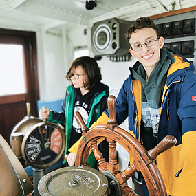 Kinder an einem Steuerrad Kinder an einem Steuerrad