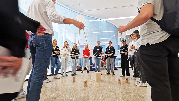 Schüler spielen ein Fadenspiel.