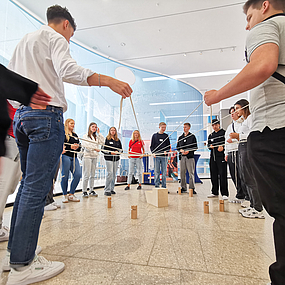 Schüler spielen ein Fadenspiel.